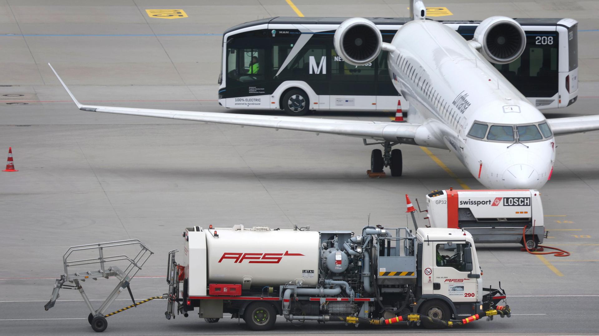 Ein Tankfahrzeug steht neben einem Flugzeug am Flughafen München | dpa