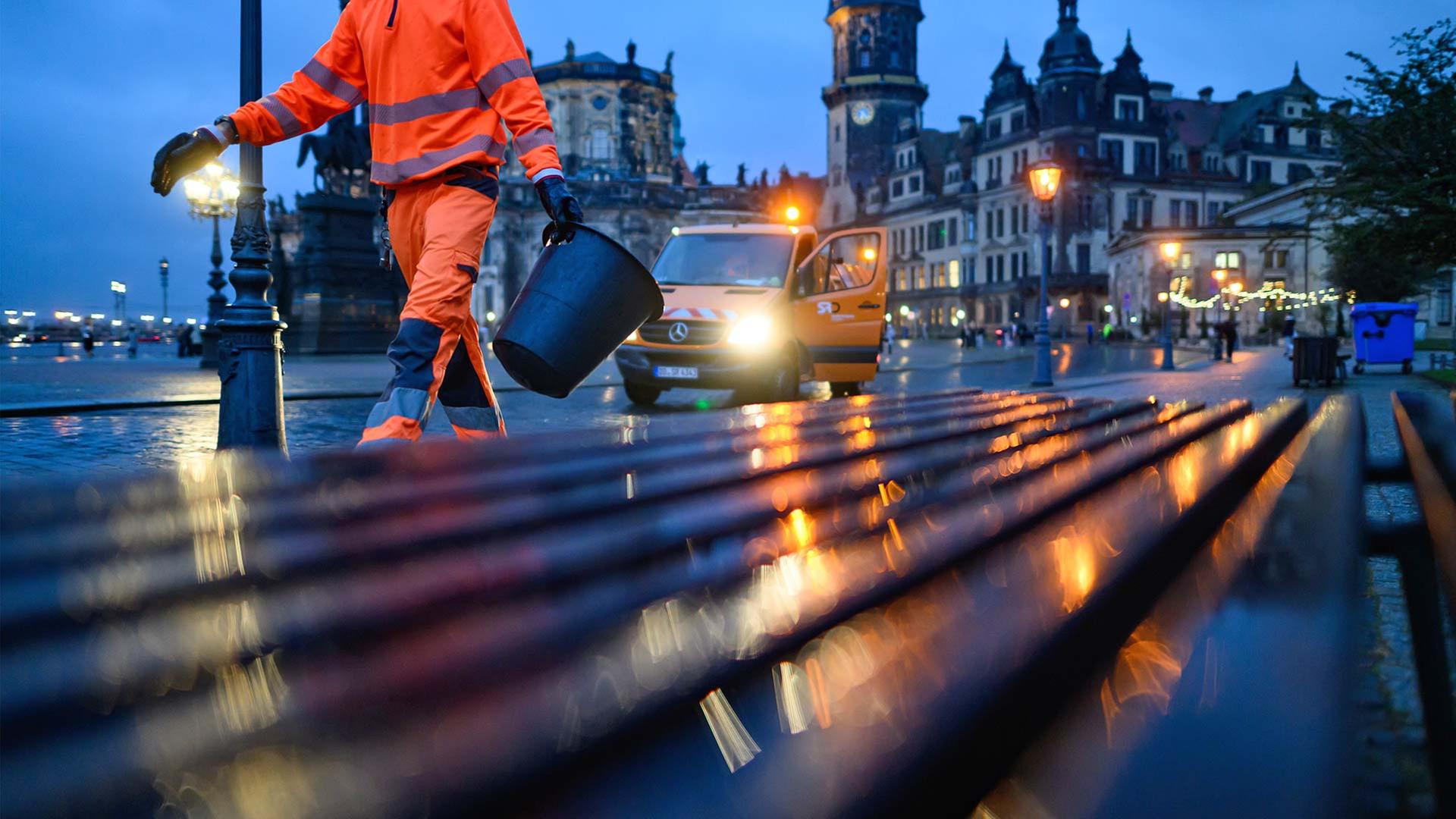 Ein Mitarbeiter der Dresdner Stadtreinigung leert am Abend MÃ¼lleimer. | picture alliance/dpa