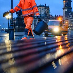 Ein Mitarbeiter der Dresdner Stadtreinigung leert am Abend Mülleimer.