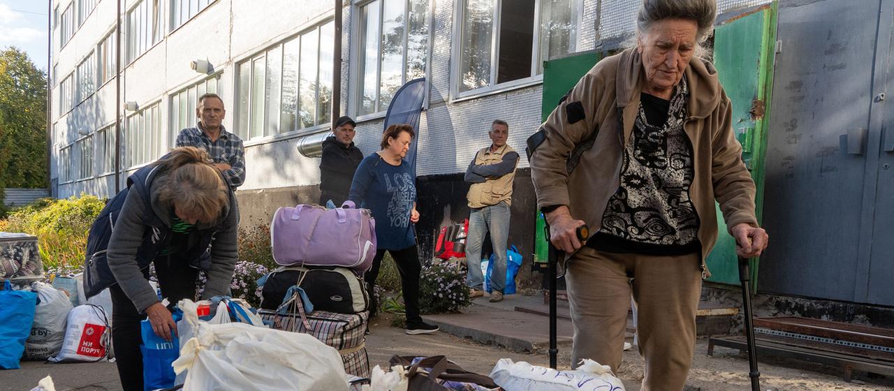 Menschen mit gepackten Taschen sind an einem Bahnhof in Lozova in der Region Charkiw (Ukraine) zu sehen.
