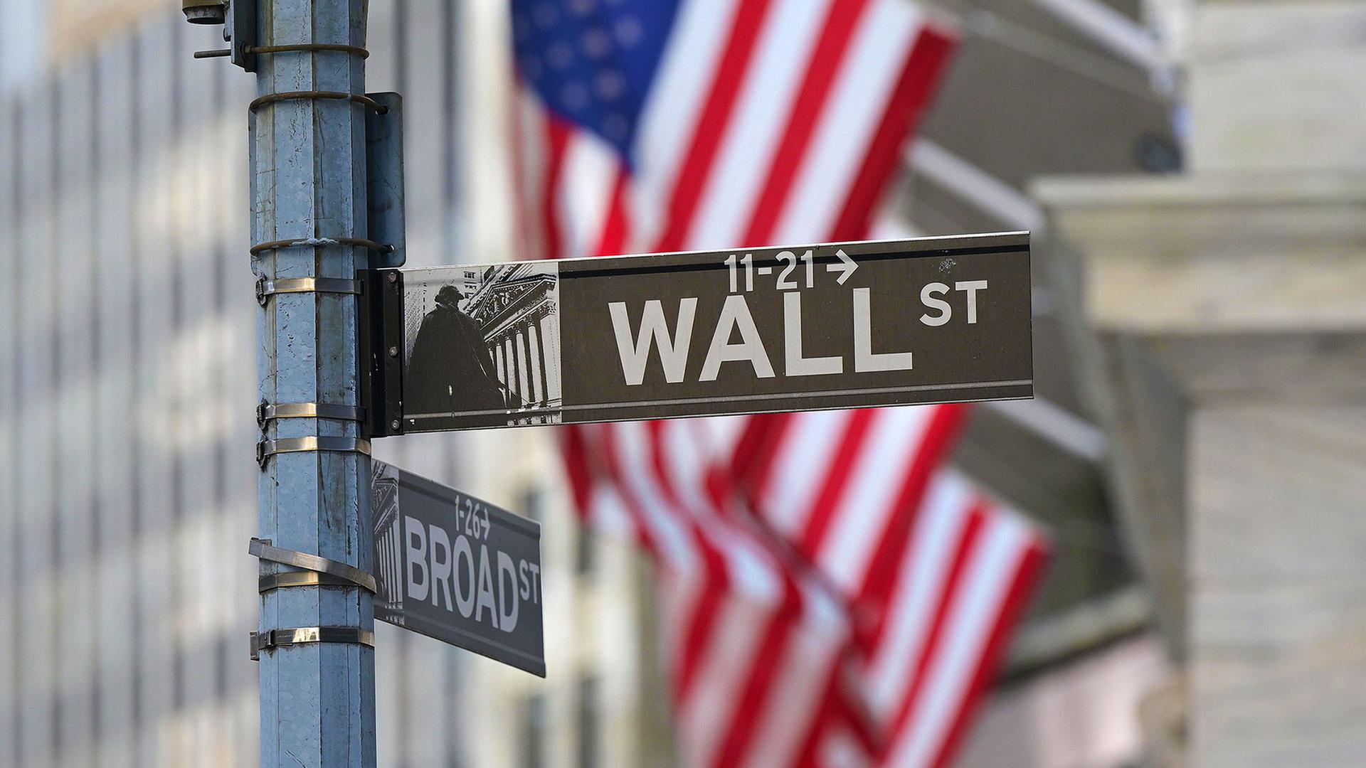 Wall Street Straßenschild vor einer amerikanischen Flagge. | picture alliance / Sipa USA