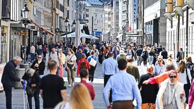 Passanten gehen in der Fußgängerzone in der Theatinerstraße in München.