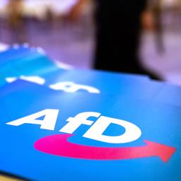 Papierfahnen mit dem AFD-Logo liegen auf einem Tisch