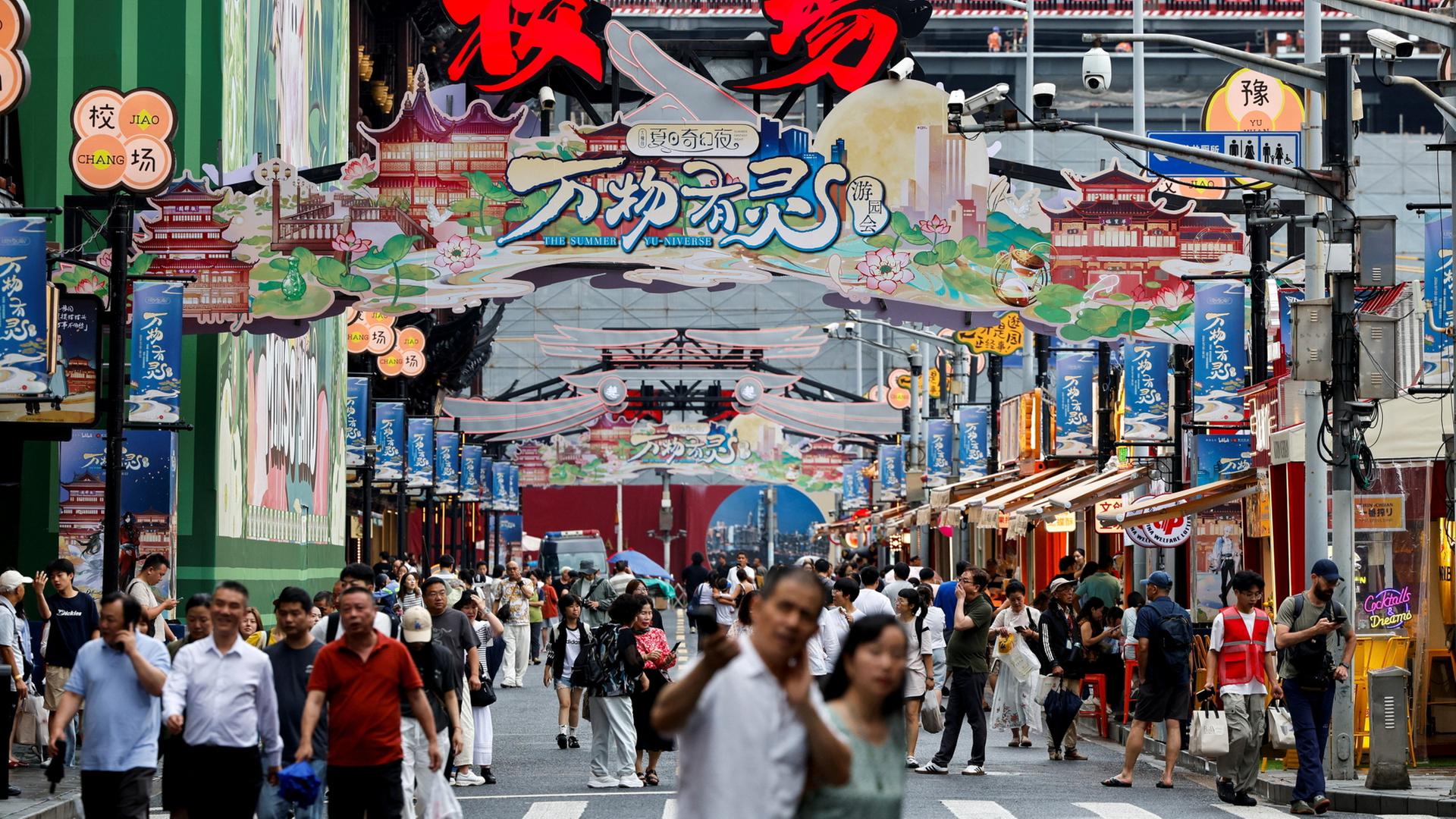 Menschen gehen eine Einkaufsstraße in Shanghai entlang. | REUTERS