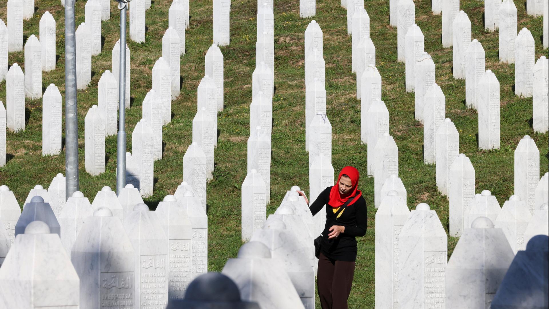 Eine bosnische Frau zwischen weißen Grabsteinen auf einem Friedhof bei Srebrenica | REUTERS