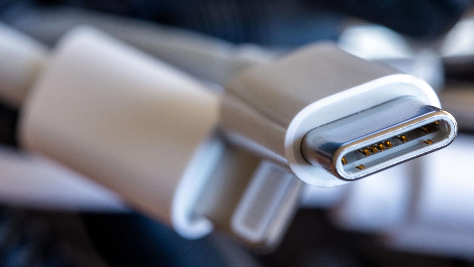 Ein Ladekabel mit USB-C-Stecker liegt neben einem Bündel unterschiedlicher Anschlusskabel.