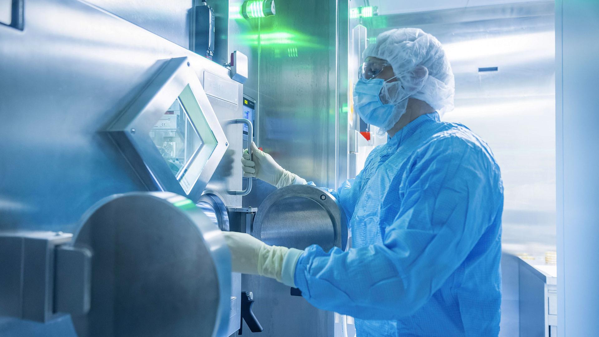 Ein Arbeiter in Schutzkleidung in einem Labor der in der Radiopharmazie. | picture alliance / imageBROKER