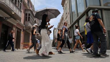 Menschen laufen bei hohen Temperaturen durch Lima, Peru. 