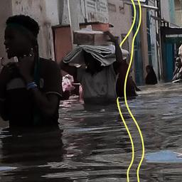 Männer gehen durch das Hochwasser auf der Straße in der somalischen Stadt Beledweyne.