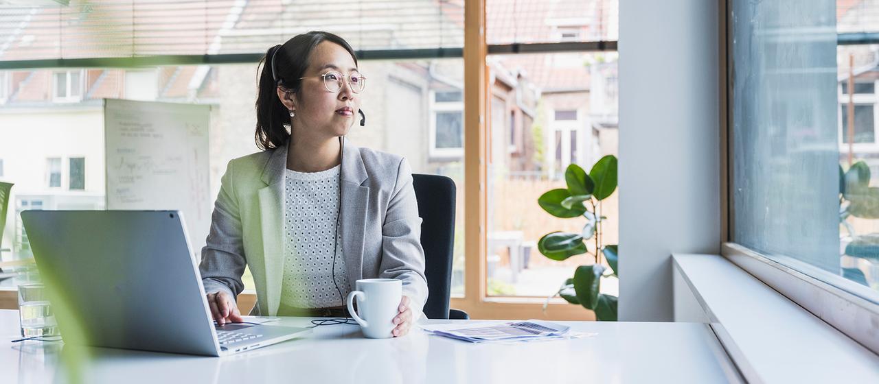 Eine Frau sitzt in einem Büro an einem Schreibtisch.