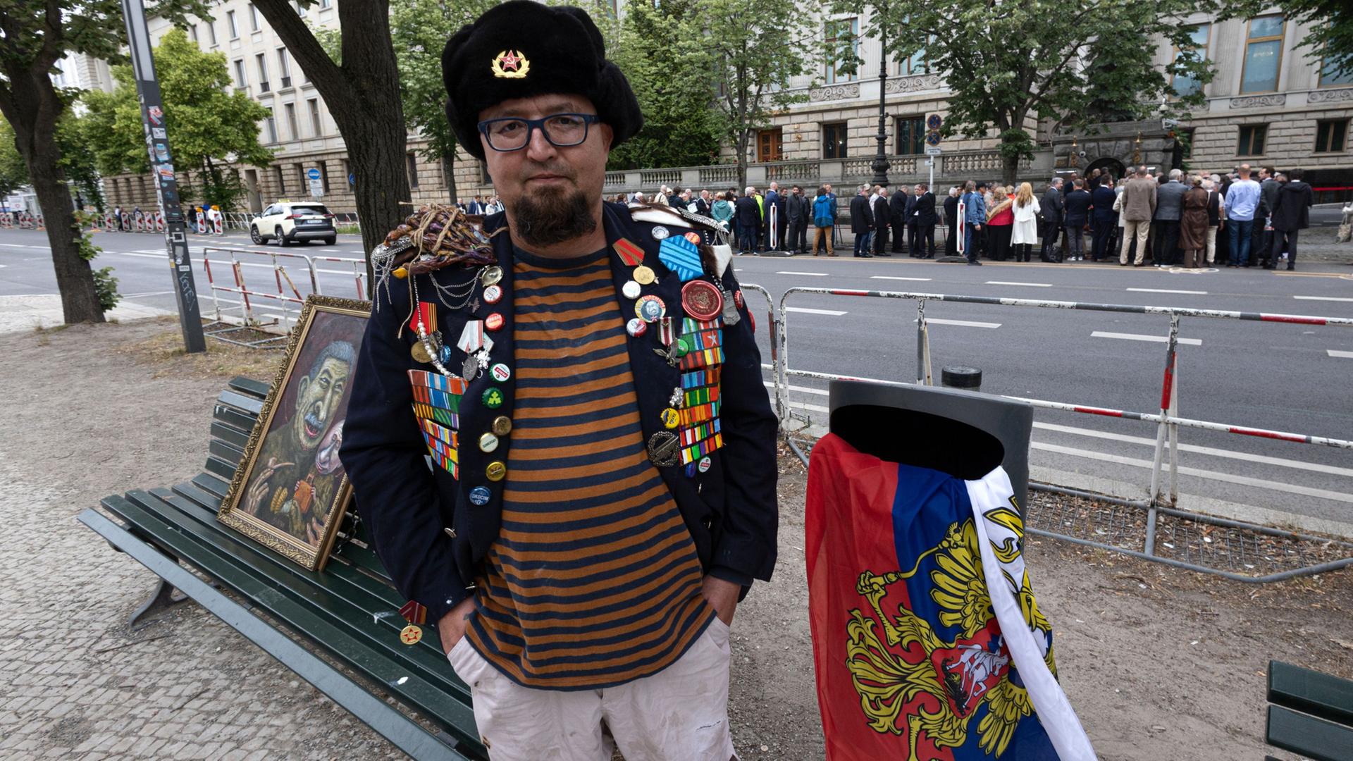 Semjon Skrepezki steht vor einem Mülleimer, in dem die russische Flagge hängt | Vasily Krestyaninov/SOTA/AP/dpa