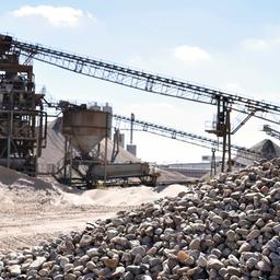 Kiesgewinnungsanlage mit Kieshaufen im Vordergrund