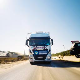 Der LKW einer deutschen Hilforganisation auf einer spanischen Autobahn. Links und rechts liegen Autowracks.