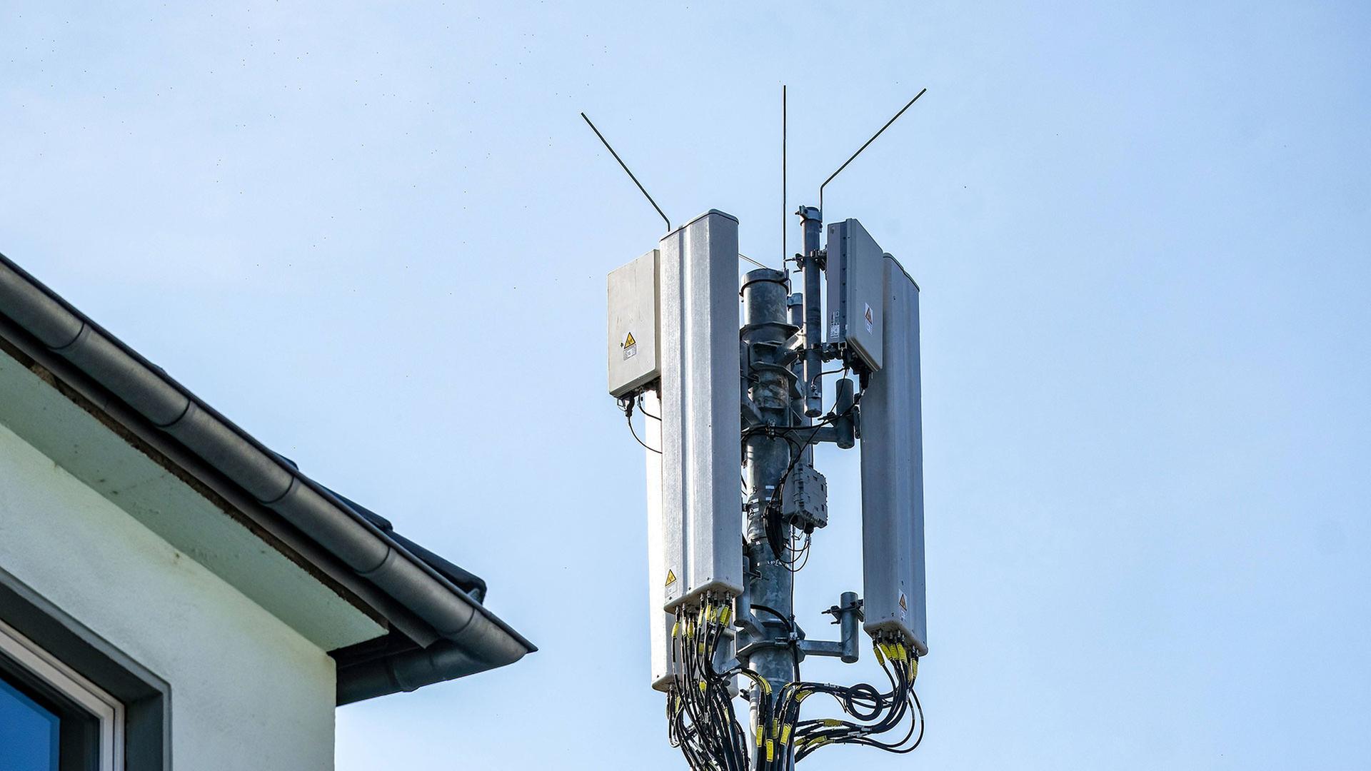 Mobilfunkmast hinter einem Wohnhaus | IMAGO / Michael Gstettenbauer