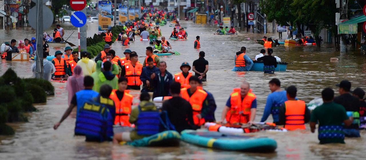 Menschen auf einer überfluteten Straße in Nha Trang 