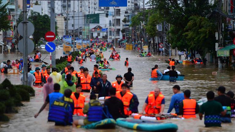 Menschen auf einer überfluteten Straße in Nha Trang 