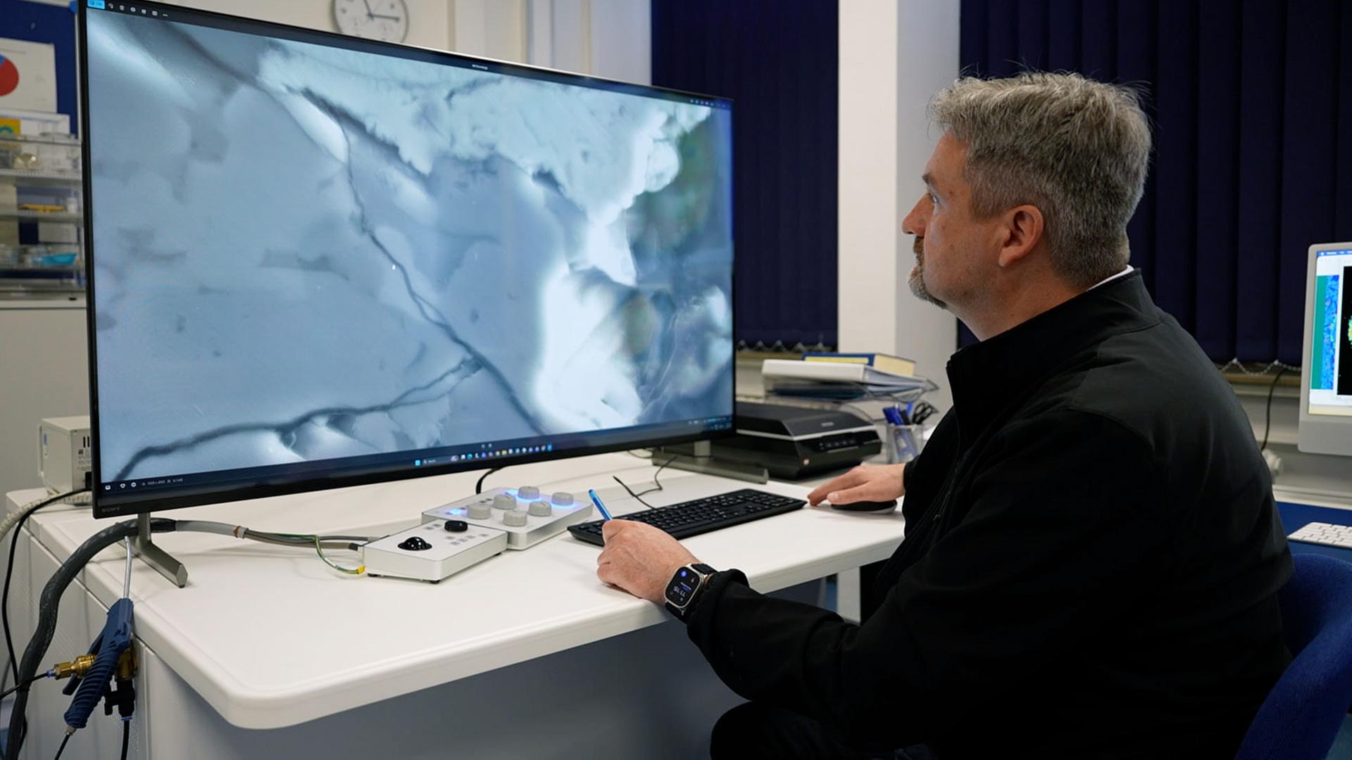 Ein Mann betrachtet eine Aufnahme auf einem großen Monitor | SWR