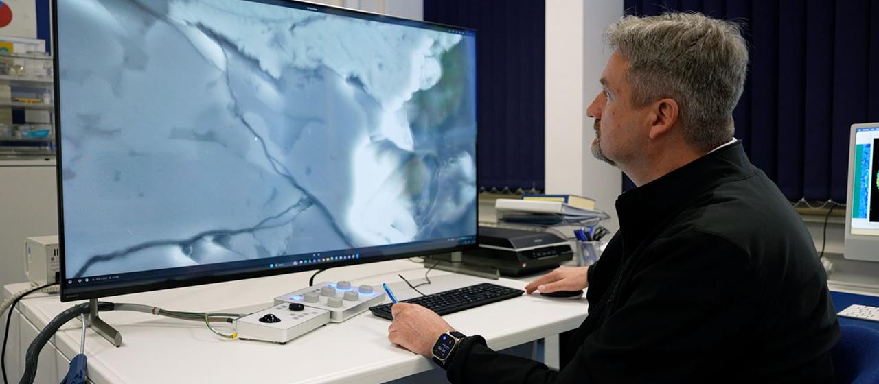 Ein Mann betrachtet eine Aufnahme auf einem großen Monitor