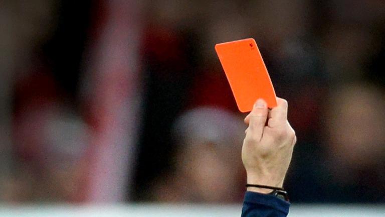 Eine Hand zeigt eine rote Karte