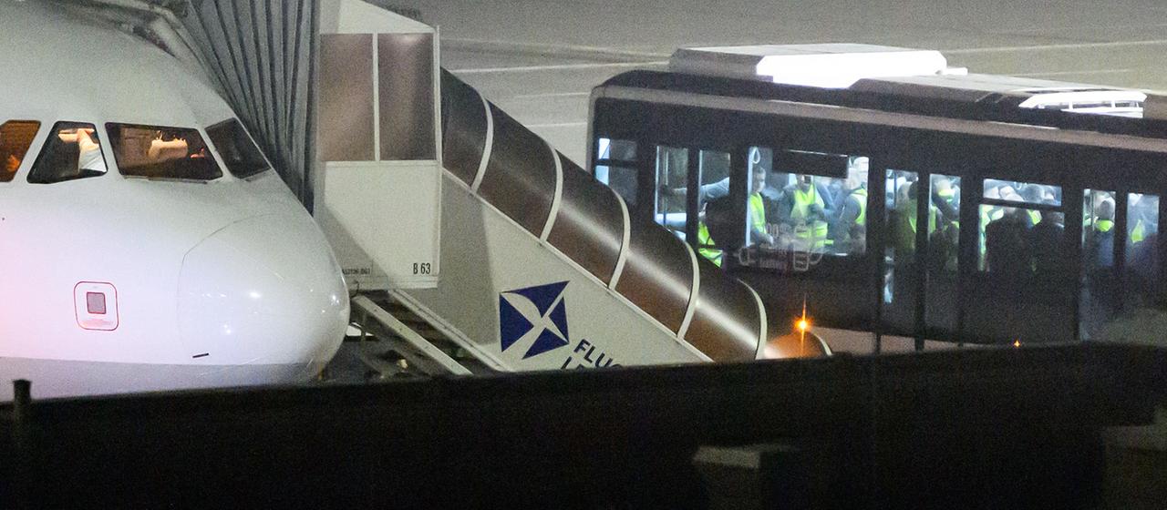 Ein Bus hält auf dem Flughafen Leipzig/Halle neben einer Maschine. 