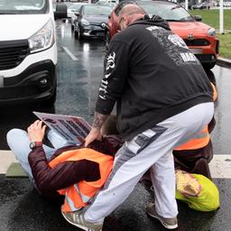 Ein Autofahrer versucht ein Mitglied der Gruppe "Letzte Generation" von der Straße zu zerren.