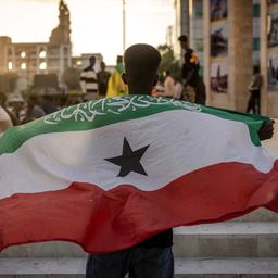 EIn Mann hält eine Flagge der Region Somaliland hoch.