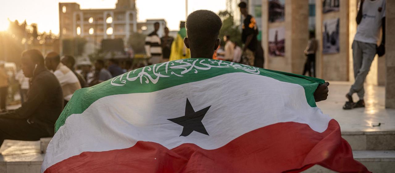 EIn Mann hält eine Flagge der Region Somaliland hoch.