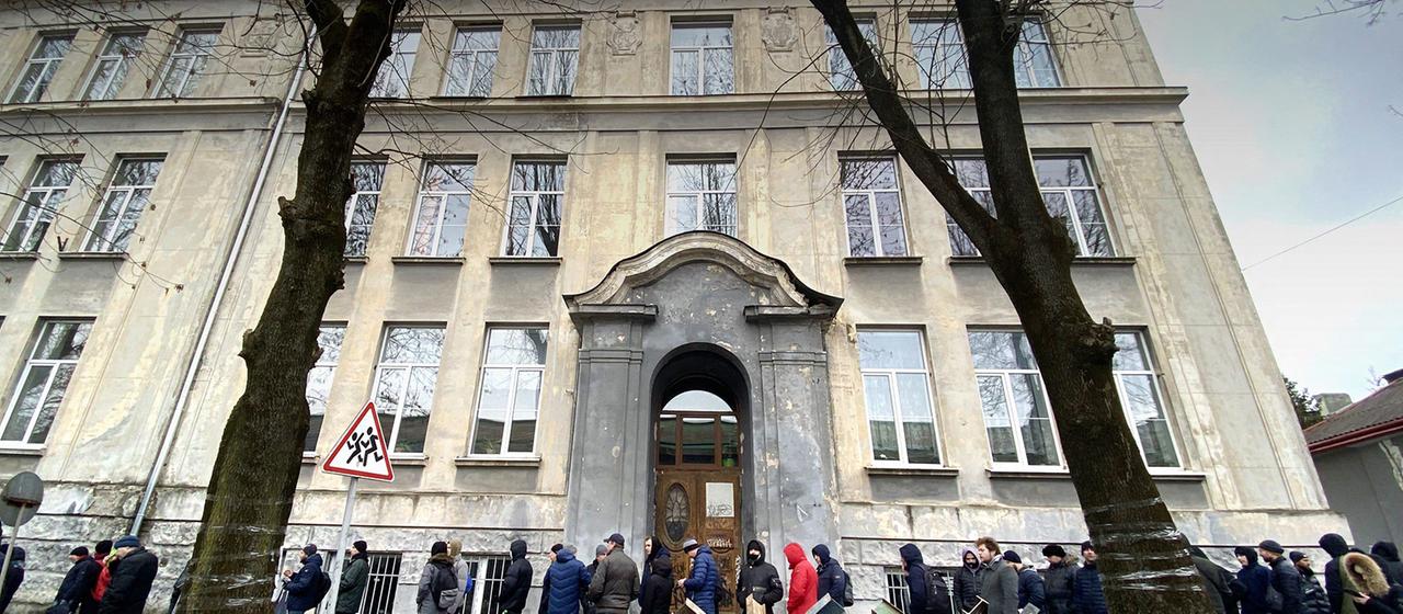 Männer stehen in einer Schlange vor einem Rekrutierungsbüro in Lwiw.