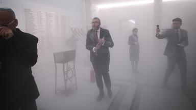 Grzegorz Braun (mi.) im Dunst von Löschschaum vor dem Chanukka-Leuchter im polnischen Parlamentsgebäude