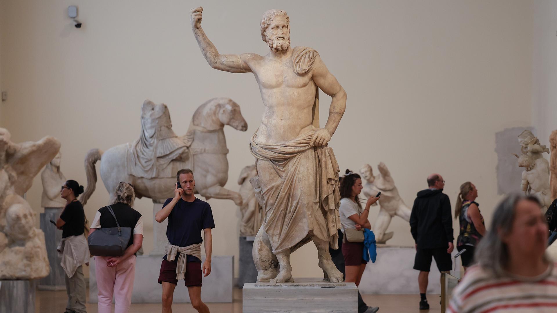 Menschen besuchen ein Museum mit antiken Statuen. | EPA