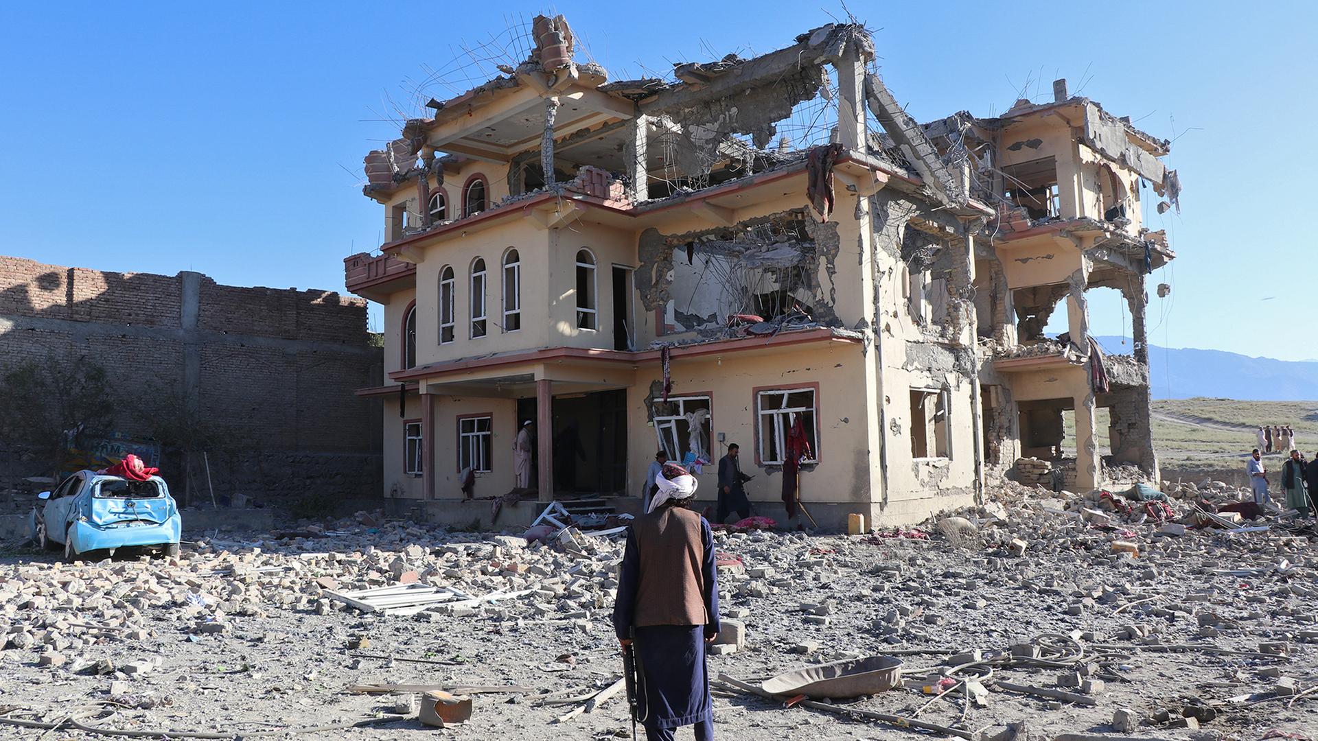 Personen inspizieren ein beschädigtes Haus in dem afghanischen Dorf Mandakhel. | EPA