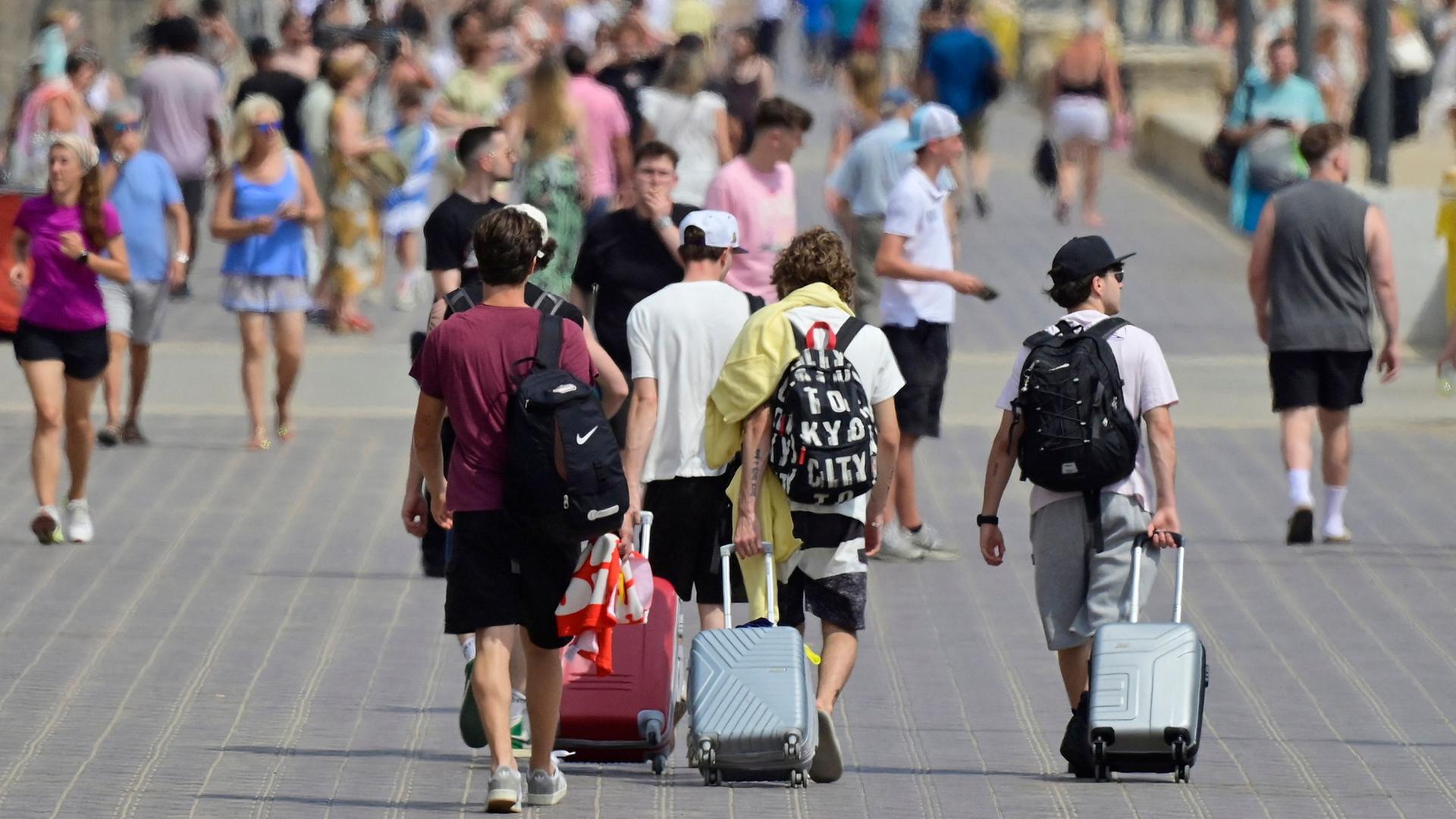Touristen ziehen Rollkoffer durch Valencia (Archivbild vom 3.8.2025) | AFP