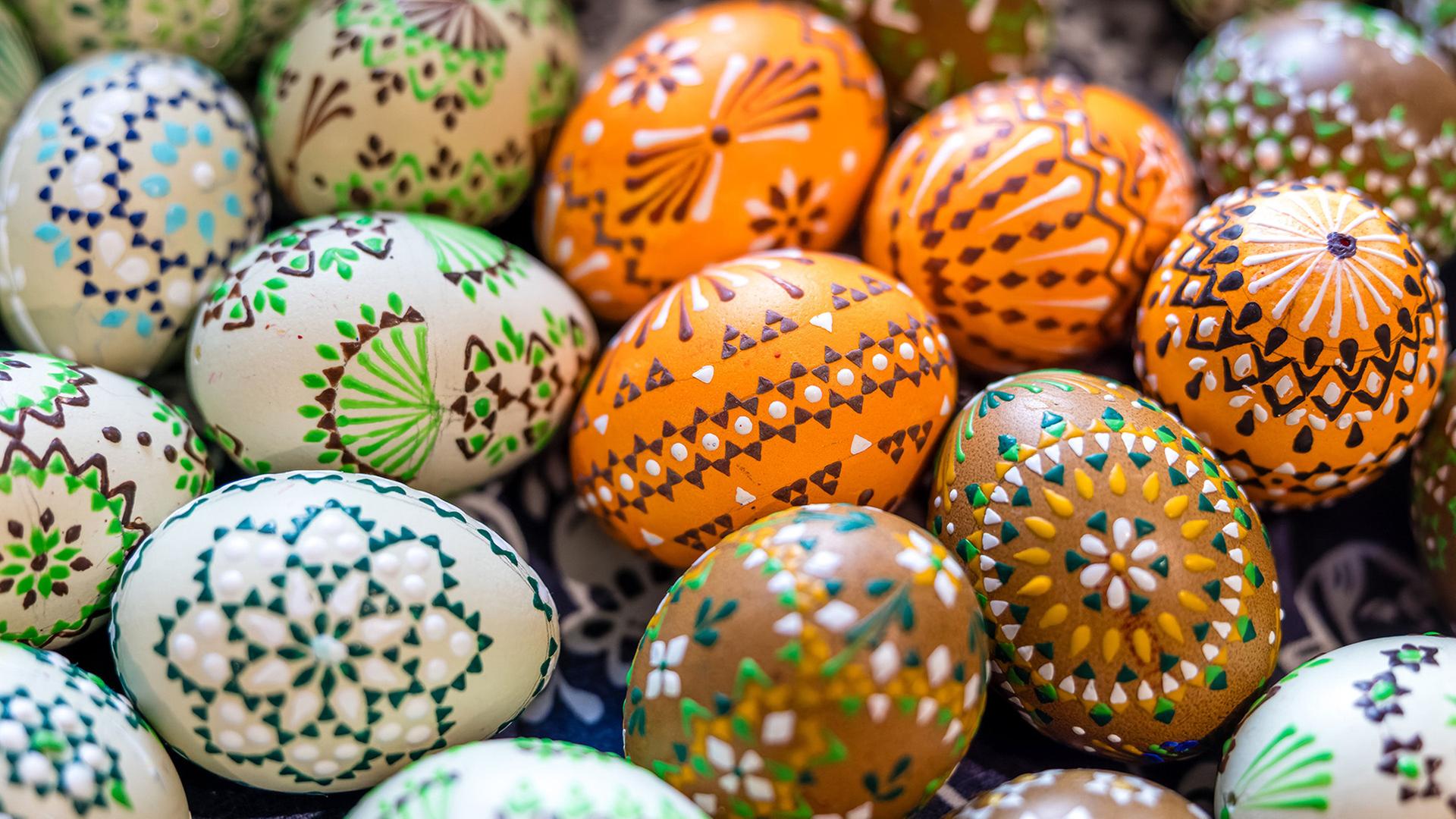 Kunstvoll verzierte Ostereier liegen in einer Schale. | Frank Hammerschmidt/dpa