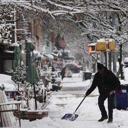 Ein Mann schippt Schnee auf einem Gehweg in Brooklyn.