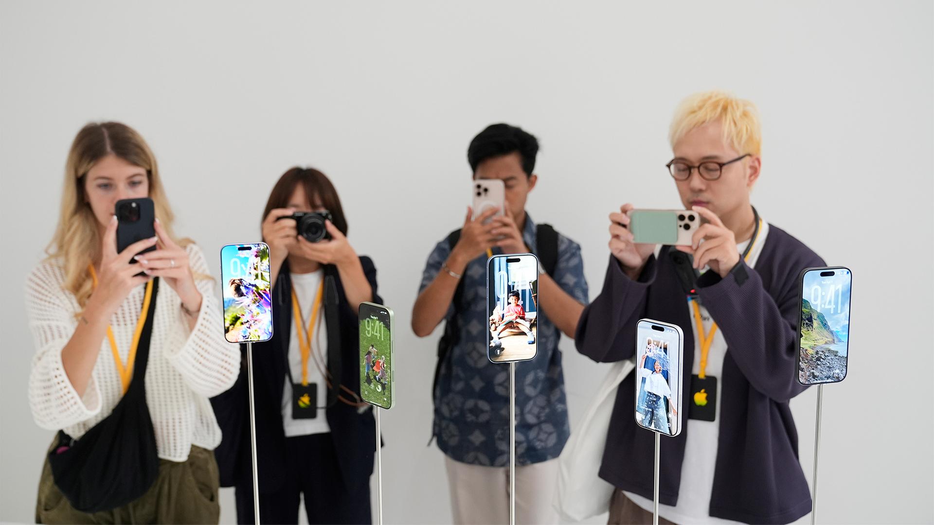 Personen beim fotografieren von iPhone Modellen. | picture alliance / ASSOCIATED PR