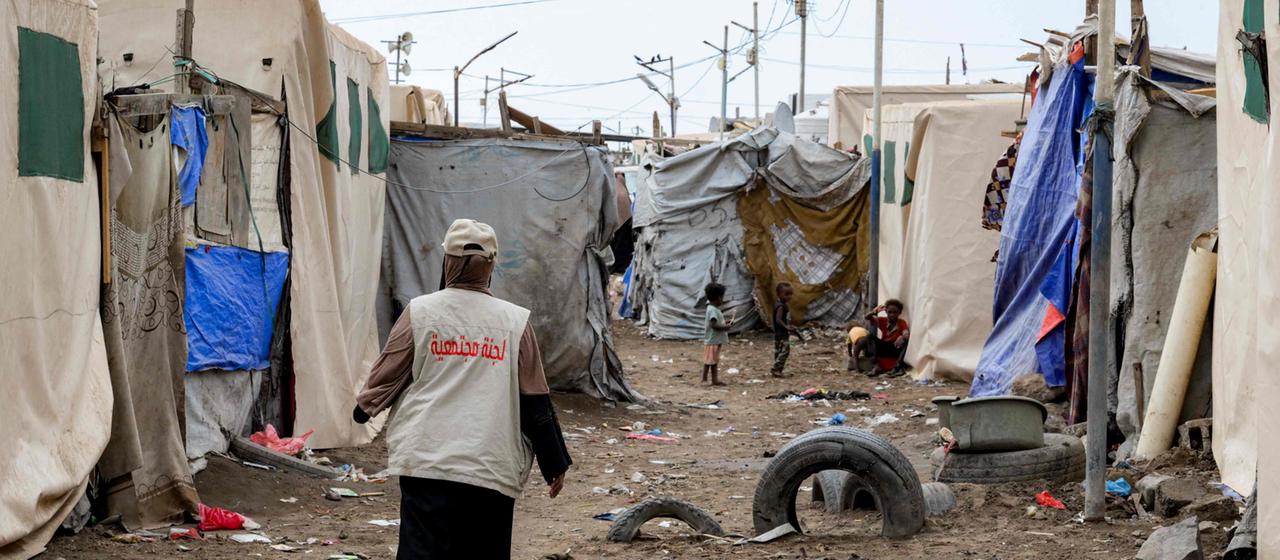 Eine Helferin geht zwischen Zelten in einer Notunterkunft für Binnenflüchtlinge im Süden des Jemen hindurch.