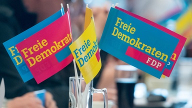 Fähnchen der FDP stehen in einem Glas.