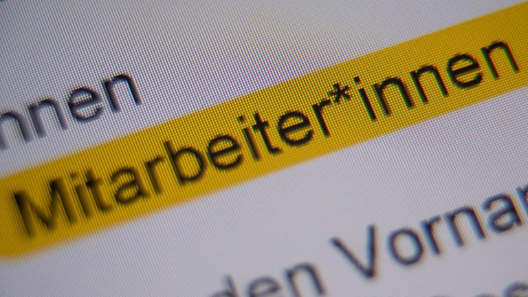 Die gegenderte Anrede Mitarbeiter*innen ist markiert und auf einem Bildschirm zu sehen.