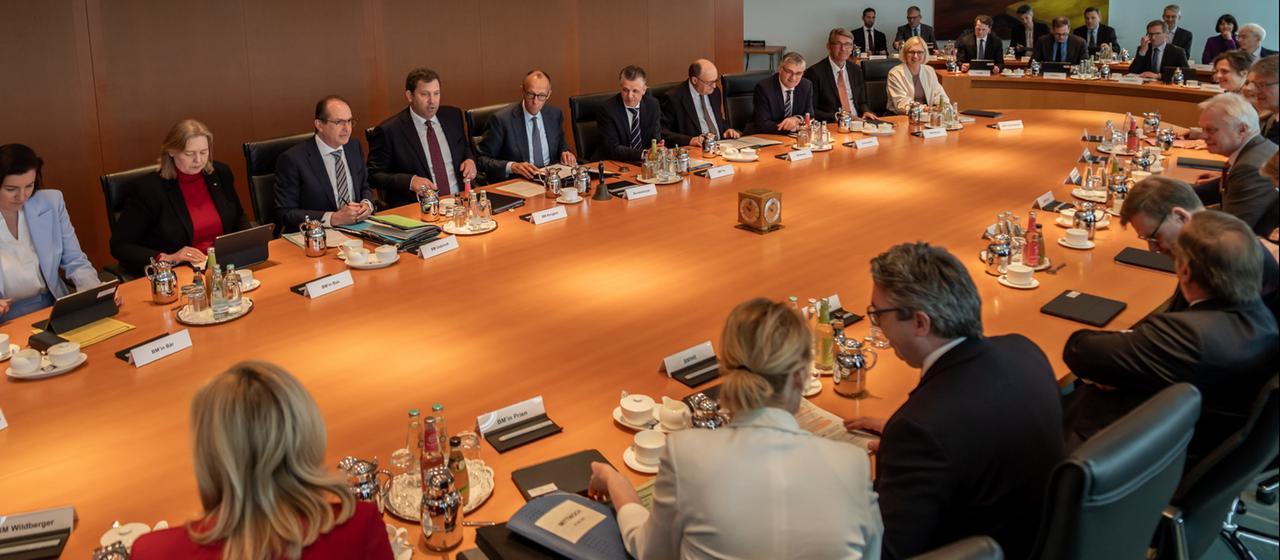 Mitglieder des Kabinetts sitzen zusammen am Kabinettstisch im Bundeskanzleramt in Berlin.
