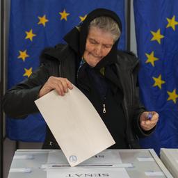 Eine Frau wirft ihren Stimmzettel in eine Urne