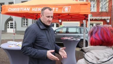 Christian Herrgott (CDU) steht an einem Wahlkampfstand (Archivbild)