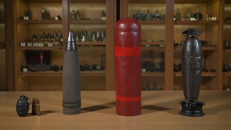 Munition (l.), Granaten, Brandbomben und Sprengbomben (r.) werden bis heute in Bremen gefunden. 50 bis 70 verschiedene Zündertypen müssen Sprengmeister kennen. | Radio Bremen Verschiedene Arten von alten Bomben stehen aufgereiht auf einem Tisch.