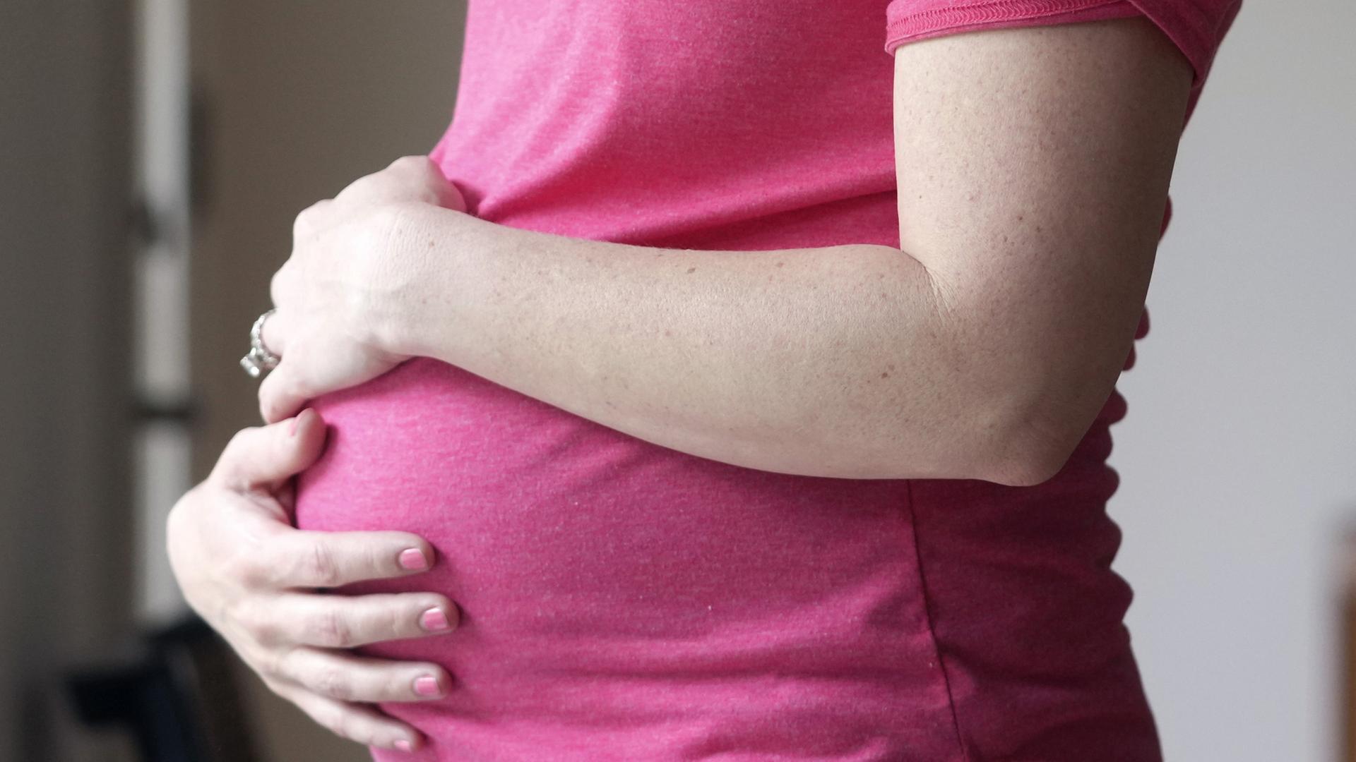 Eine Schwangere Frau hat die Hände auf ihren Bauch gelegt. | AP