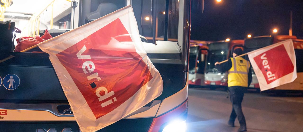An employee walks along parked buses in the Bonn public utilities bus depot.