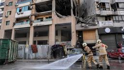 Mitglieder des Zivilschutzes stehen vor dem von einem Drohnenangriff getroffenen Gebäude im südlichen Vorort von Beirut im Libanon