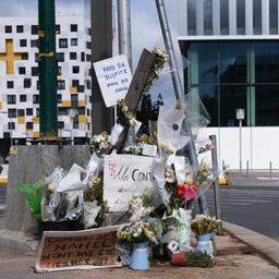 Ein Polizeiauto fährt vorbei an dem Ort vorbei, an dem Nahel M. erschossen wurde. Menschen haben Blumen und Botschaften hinterlassen. 