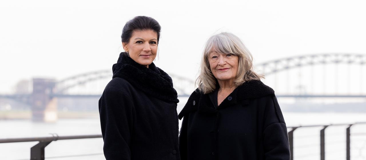 Sahra Wagenknecht und Alice Schwarzer stehen im Rheinauhafen am Rhein. 