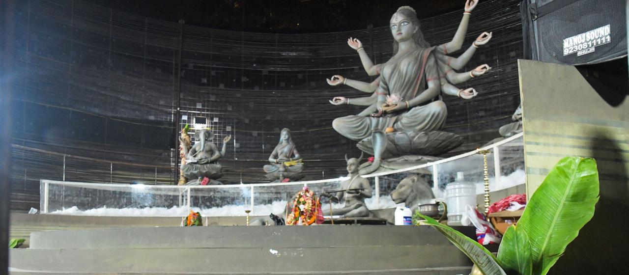 Geldbörsen und andere Gegenstände liegen auf dem Boden einer Kultstätte für das hinduistische Durga-Puja-Fest.