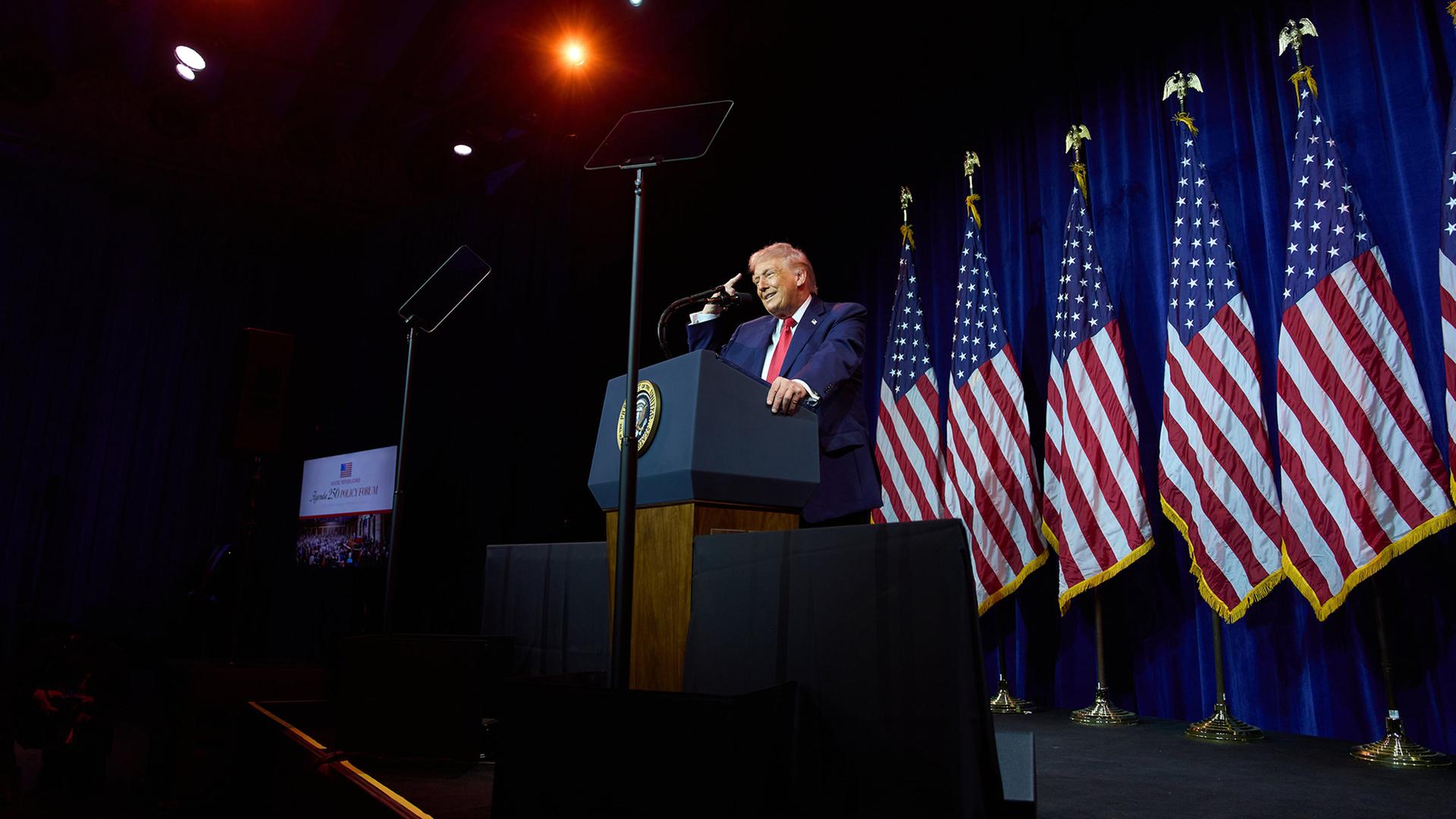 Donald Trump steht hinter einem Rednerpult und spricht vor republikanischen Abgeordneten. | AP