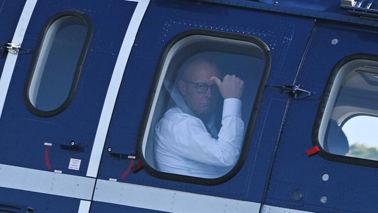Friedrich Merz blickt aus dem Fenster eines Helikopters.